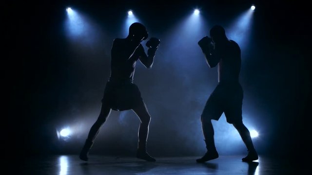 Two young sportsman are boxing in the studio
