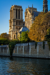 Notre Dame de Paris cathedral at sunset with the Seine River on Ile de La Cite. Autumn evening in...