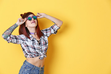 Beautiful girl with tattoo on color background