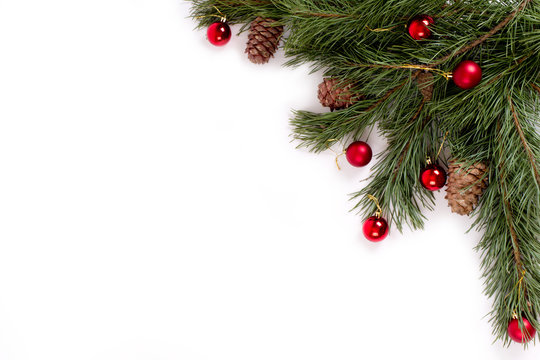 Pine branch with cones and balls on white background