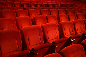  Red colored empty movie theater chairs in row