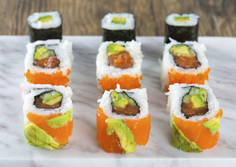 Delicious mixed sushi arranged on white marble surface