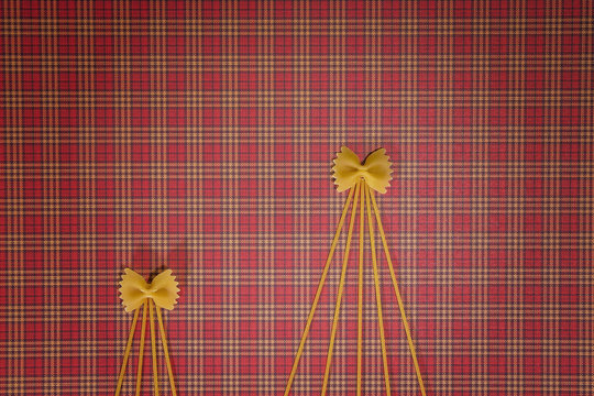 Christmas trees made of pasta on red squared background. Flat lay. Top view. Winter holidays concept