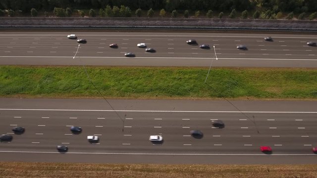 Aerial of 10 lane highway with traffic. Cars look like toys.