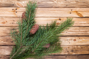 Pine branches with cones on wooden table