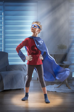 Little boy dressed as super hero in his living room