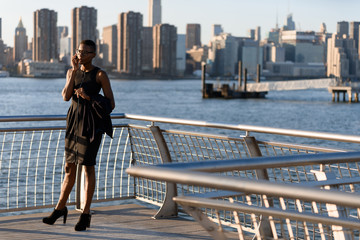 African business woman talking on the phone outdoor, New York, Manhattan, skyline view