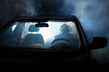 girl smoking cigarette in car full of smoke at night with gas mask