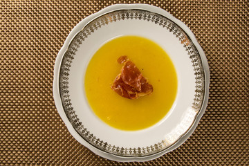 Pumpkin Soup with proschiuto on table