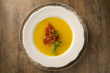 Pumpkin Soup with proschiuto on table