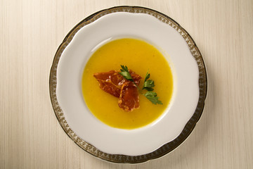 Pumpkin Soup with proschiuto on table