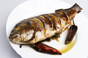 Cooked fish sea bream fish with lemon, parsley,garlic.