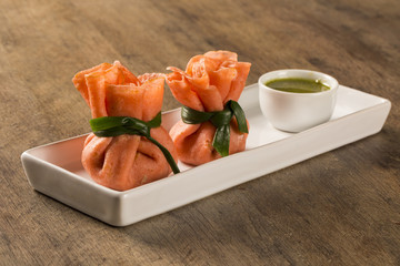 Pepper stuffed pepperloaf with pesto leg on a wooden background