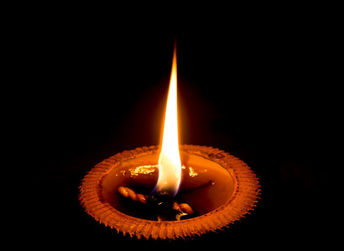 light candle burning brightly in the black background.Candle lig