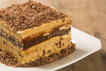 close up of a chocolate cream cake on white plate