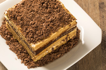 close up of a chocolate cream cake on white plate