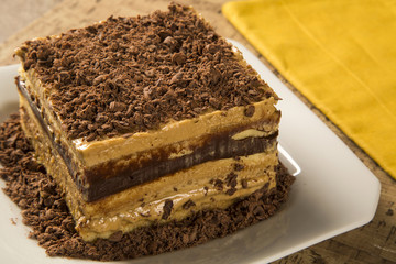 close up of a chocolate cream cake on white plate