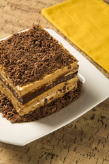 close up of a chocolate cream cake on white plate