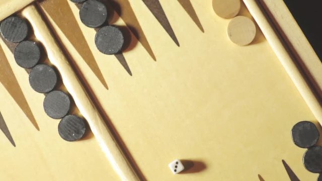 Panning shot of a backgammon board with dice, double three.