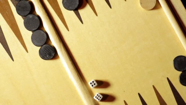 Panning shot of a backgammon board with dice, four-six.