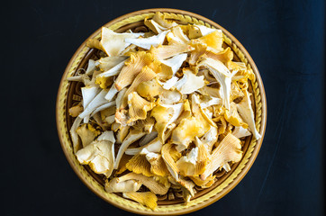 Bowl of wild fresh chanterelle mushrooms isolated on black background