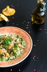 Delicious risotto with porcini mushrooms over rustic black background