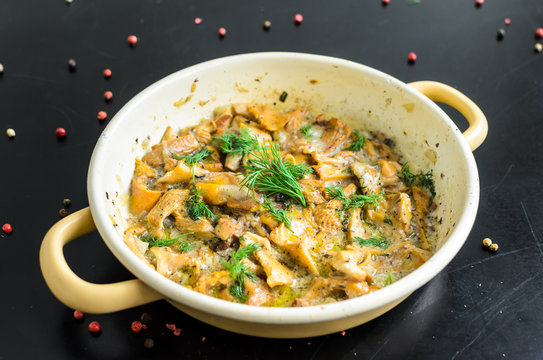 Homemade baked chanterelle mushrooms in frying pan isolated