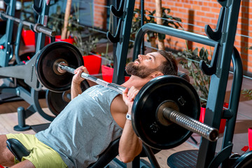 Obraz na płótnie Canvas Sports man lifting barbell in the gym