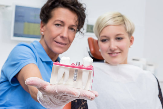 Zahnärztin bespricht mit Patientin ein Implantat