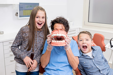 Zahnärztin hat Spaß mit zwei jungen Patienten