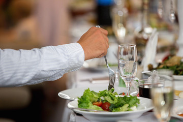 man eating a salad in a restaurant