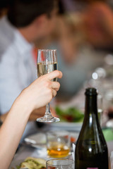 A girl holding a glass of champagne in hand. Festive evening in the restaurant.
