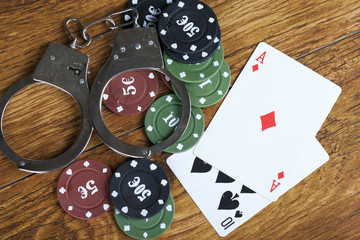 Illegal gambling concept blackjack with betting chips and handcuffs