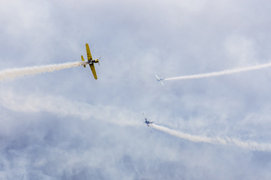 avia show. 3 small aircrafts depict acrobatics in the sky blowing smoke