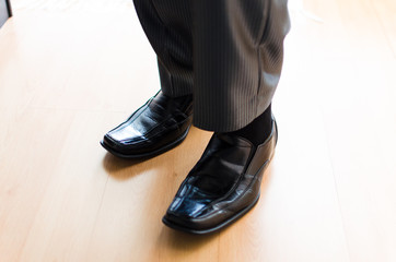 Business man is putting on elegant shoes