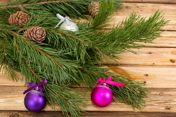 pine branch with cones and balls on a wooden table