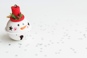 Christmas and New Year background with Snowman decorative ball for Christmas tree. Holiday background with stars confetti. Place for text.