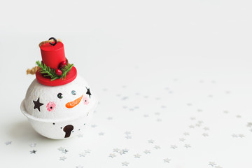 Christmas and New Year background with Snowman decorative ball for Christmas tree. Holiday background with stars confetti. Place for text.