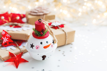 Christmas and New Year background with Snowman decorative ball, presents and decorations for Christmas tree. Holiday background with stars confetti and light bulbs. Place for text.