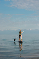 woman on paddle board mountains background