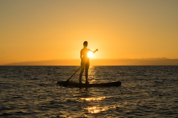 girl on paddle board in sunset