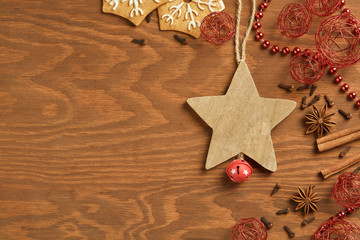 Christmas gingerbread on brown, wooden background with various decoration and spices