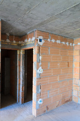 Electric sockets installation in brick walls at house construction site