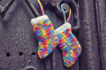 Handmade knitting socks with ornament hanging on ribbon. Christmas handmade decorations. Christmas colored boots in anticipation of Santa's gifts. Colorful Christmas stocking decoration element