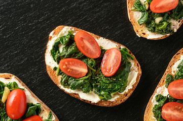 Toasts with spinach, cream cheese and tomatoes.