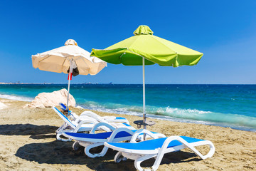 Summer beach with sun beds and umbrellas.