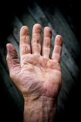 A man holds his hand in front of him. His hand on top.
