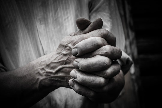 A man holds his hands in front of him. Fingers intertwined.
