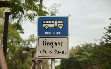 Bus stop sign on pole next to the road