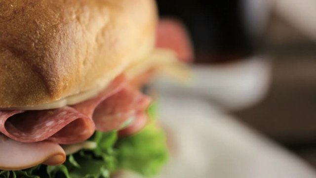 Sub sandwich with fresh vegetables, lunch meat and cheese on hoagie roll